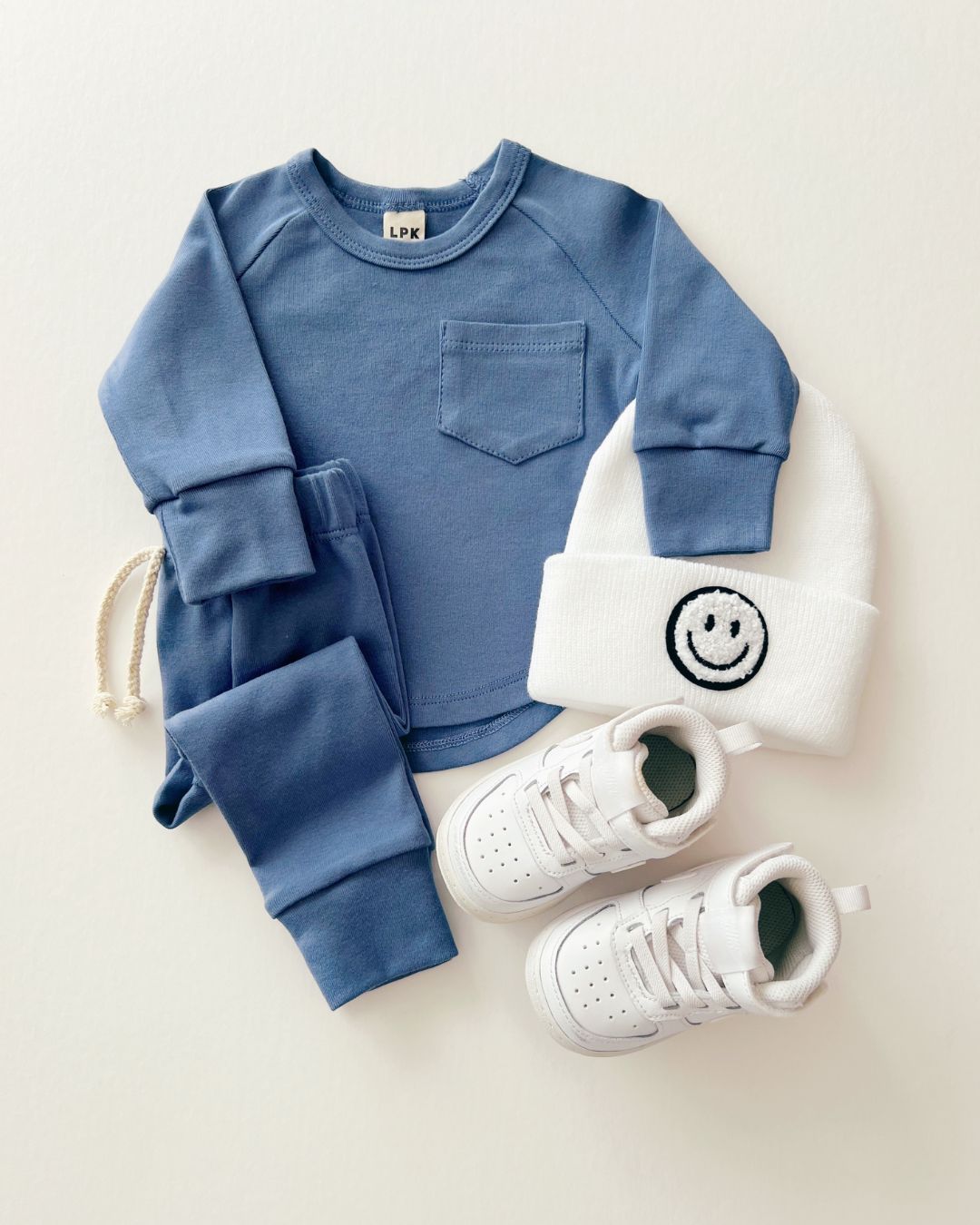 A cotton Ocean Blue Lounge Set from Lucky Panda Kids which includes a pair of pants and a long sleeve shirt that match. 